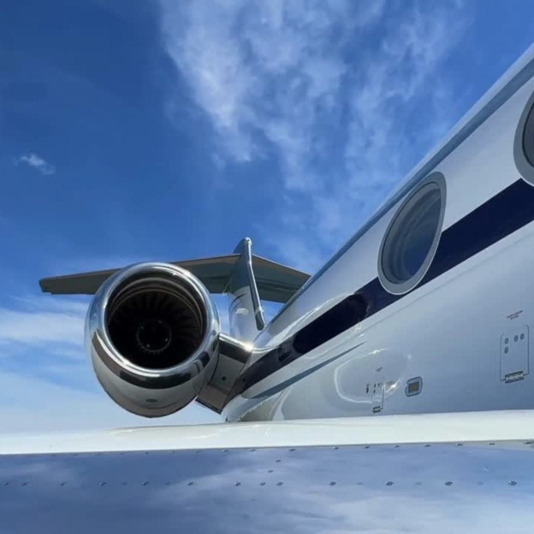 Close-up view of a private jet engine on an airport tarmac, illustrating the worldwide private, commercial and cargo charter capabilities offered by IONA JETS.